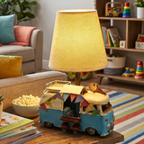 Decorative lamp shaped like a camper van on a table in a cozy living room.