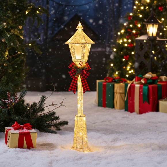 Decorative Christmas lighted lamp post with presents and trees in a snowy setting