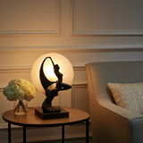 Decorative table lamp on a side table with a vase of flowers in a room setting.