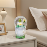 Decorative snow globe with floral design on a nightstand