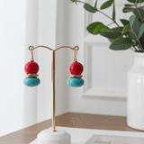 Colorful earrings on a stand with a blurred indoor background