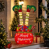 Decorative Christmas display with elf legs, candy cane, and 'Merry Christmas' sign on a porch.