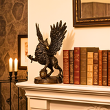 Decorative statue of a winged creature on a mantelpiece with books and candles.