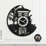 Doctor Who-themed wall clock on a white wall with a small candle holder in the corner.