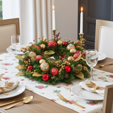 Decorative Christmas wreath on a table with place settings and candles.
