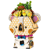 Decorative planter shaped like a koala with polka dot design and colorful bow tie on a white background.