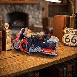 Model of a person on a motorcycle with Route 66 decor elements on a wooden surface.