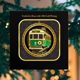 Decorative item with a tram design and gold plating, set against a festive background.