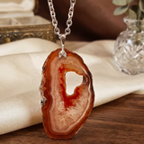 Agate pendant necklace on a wooden surface with a neutral background