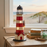Decorative lighthouse lamp on a table with a window view of a beach.