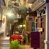 Miniature model of a bookshop with a mailbox and decorative elements.