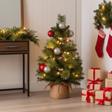 Decorated Christmas tree with lights, ornaments, and presents in a room setting.