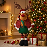 Decorative reindeer figure in a festive setting with a Christmas tree and presents.