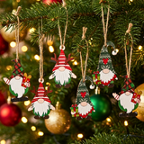 Decorative Christmas gnome ornaments hanging on a tree with lights in the background